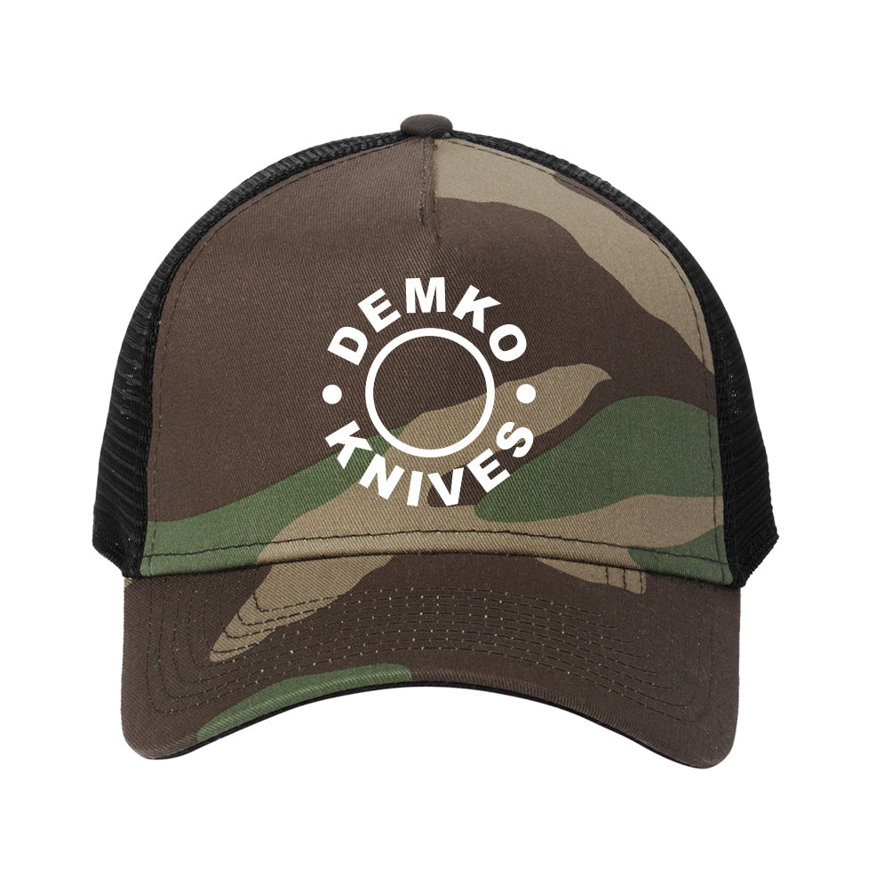 Demko Knives white embroidered logo on a camo and black trucker hat.