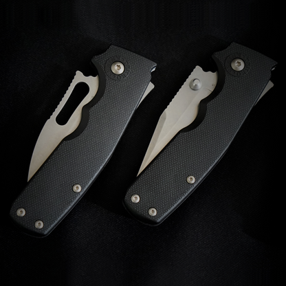 Two Shark-Cub folding knives closed with black handles and stonewashed blades on a dark background.