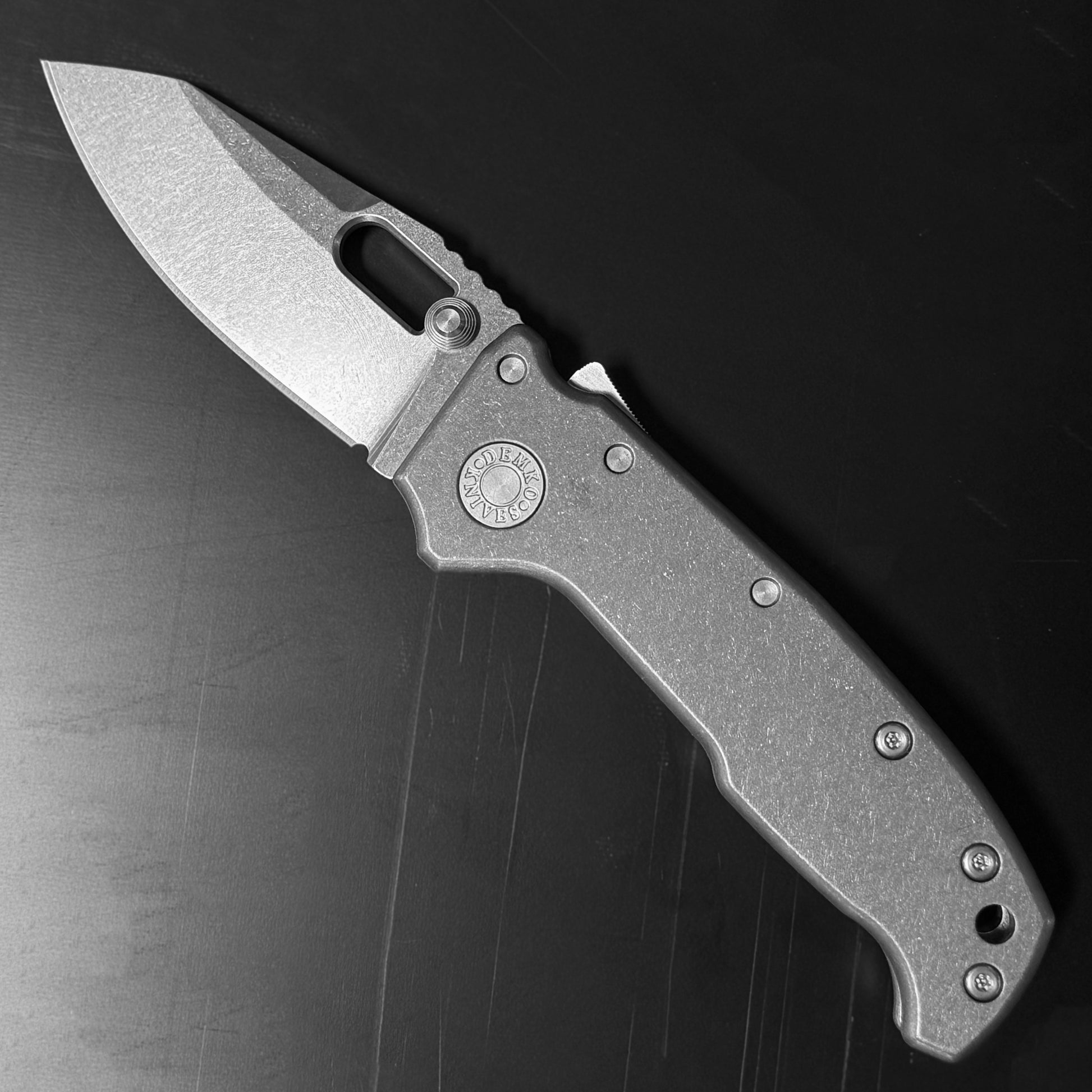 Demko AD20 Compact Knife with MagnaCut steel blade, smooth titanium handle, and Demko Shark-Lock, front side open view on dark background.