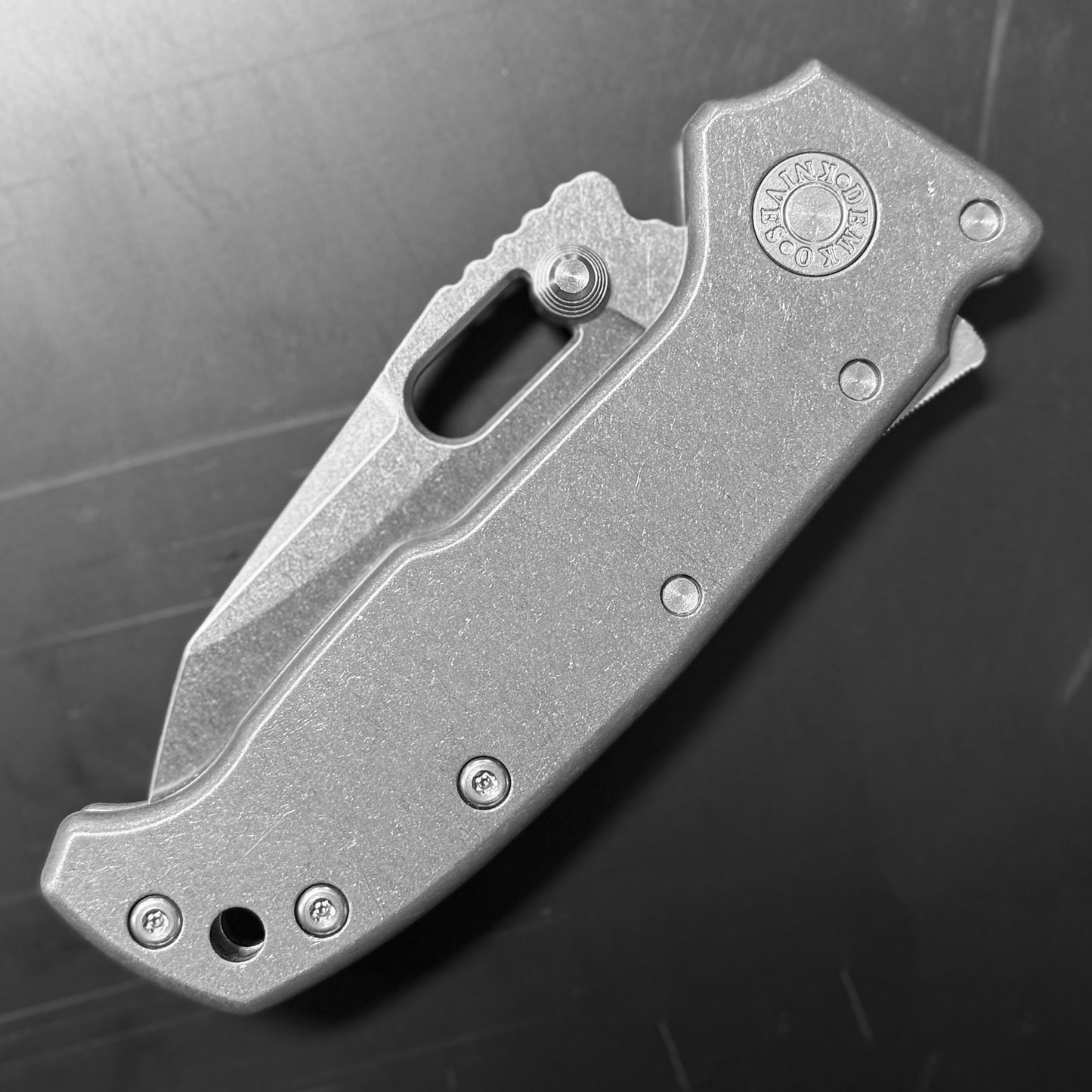 Demko AD20 Compact Knife with MagnaCut steel blade, smooth titanium handle, and Demko Shark-Lock, back side closed view on dark background.