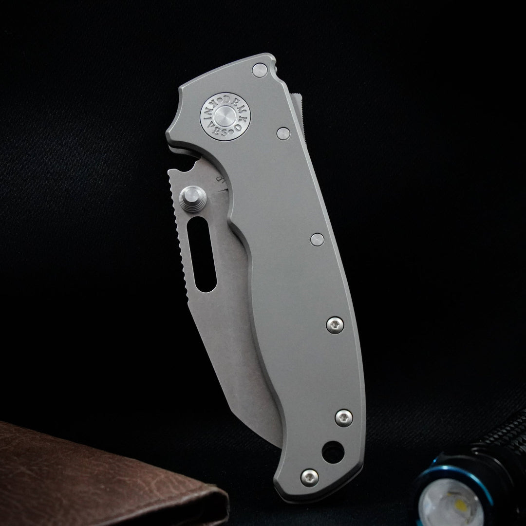 AD20.5 CPM 20CV shark foot folding knife with a smooth titanium handle with a leather wallet and flashlight.