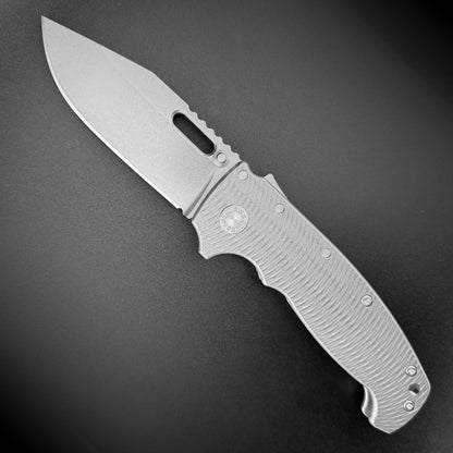 AD20 XXX 3V folding knife with slotted clip point blade and milled titanium handle.