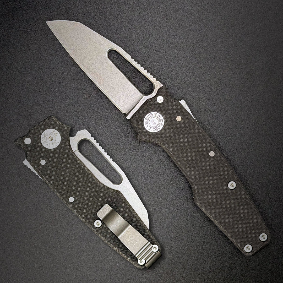 American made AD22 MagnaCut folding knife with carbon fiber handle on a dark gray background.