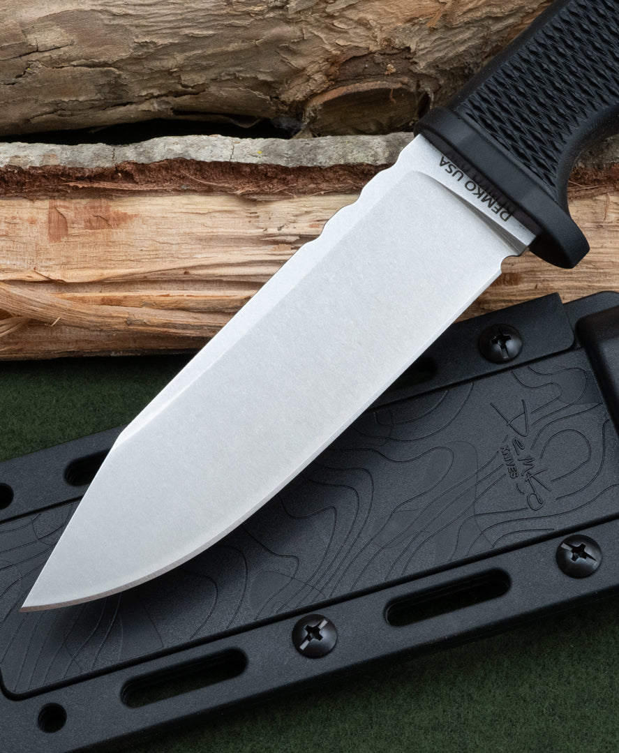 American made FreeReign fixed blade knife with a black handle and silver blade on a wooden surface.