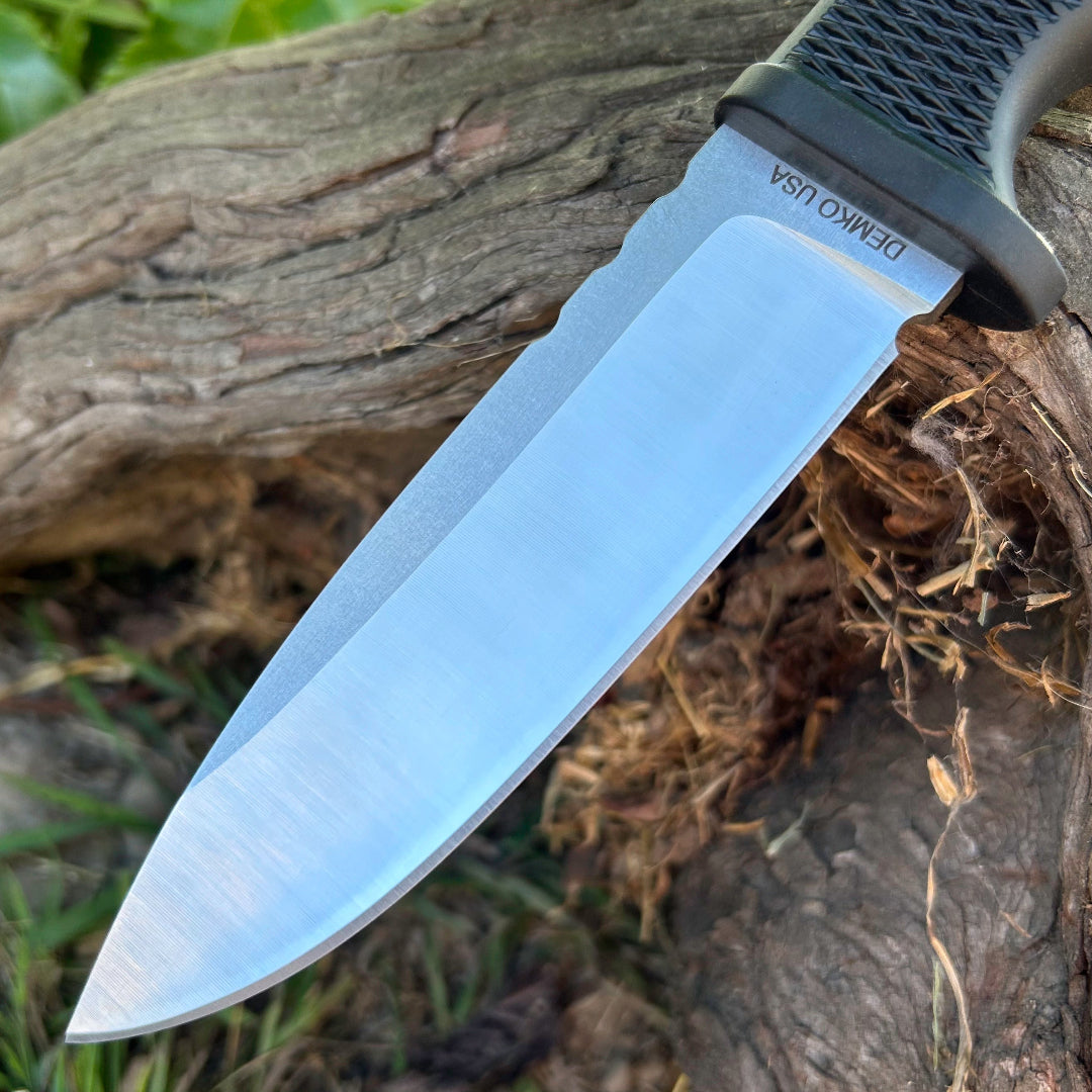 Close up view of an American made FreeReign blade on a piece of wood in an outdoors setting.